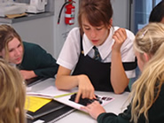 A Year 12 student explains work to a group of younger students