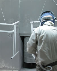 Powder coating is done at the Furnware factory - a dry powder is sprayed alongside the unit and is attracted on to the surfaces using electrostatic forces.