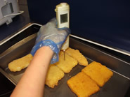 Checking the temperature of the crumbed fish