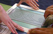 A photo of two students screen printing a koru