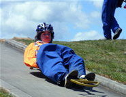 A student riding his luge down the track